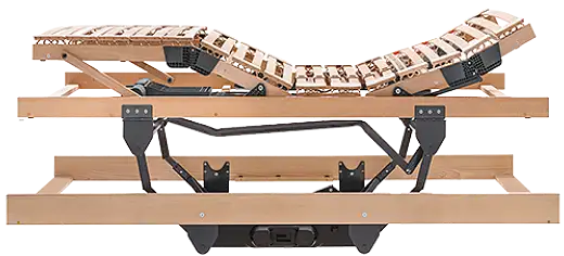 Ein stabiler Rahmen, in dem eine ausgefahrene Hebemechanik eingebaut ist. Auf einem schwarzen Unterbau, der am Boden steht, heben Stützen einen zweiten Rahmen nach oben. Darauf ist ein Lattenrost montiert, der sich über einen Motor über jeweils 2 Scharniere an Kopf- und Fußende verstellen lässt.